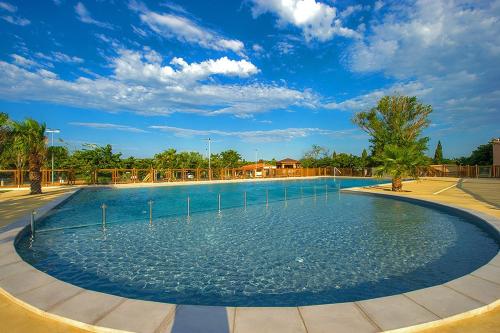 une grande piscine d'eau dans un parc dans l'établissement Mobil home 5-6 personnes - climatisé, à Port-la-Nouvelle