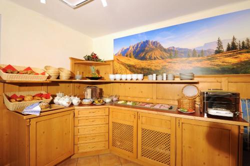 Una cocina con un gran cuadro en la pared. en Aparthotel Kristall, en Altenmarkt im Pongau