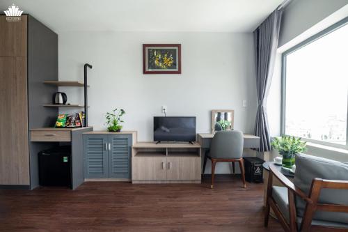 a living room with a desk and a television at Cali Hotel Quy Nhơn in Quy Nhon