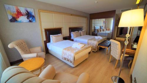 a hotel room with two beds and a living room at Wyndham Batumi in Batumi