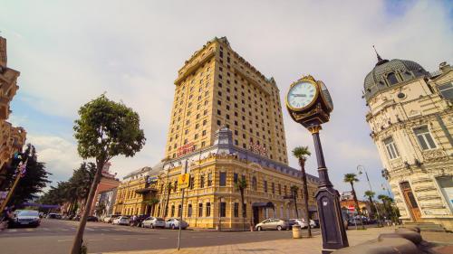 a tall building with a clock in front of it at Wyndham Batumi in Batumi