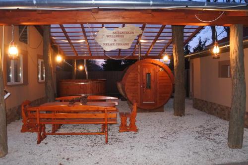 a room with a wooden bench and a barrel at Tessedik Vendégház in Hajdúszoboszló