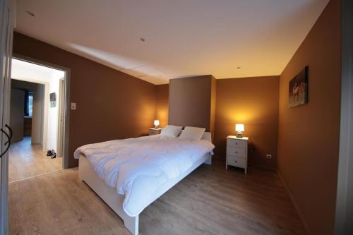 a bedroom with a large bed and two night stands at la perle grise de la semois in Bouillon