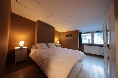 a bedroom with a large bed and a window at la perle grise de la semois in Bouillon