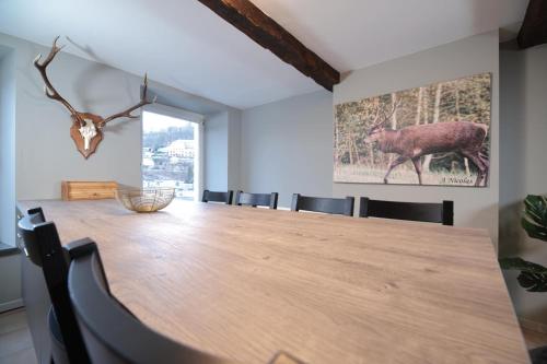 a dining room with a large wooden table and chairs at la perle grise de la semois in Bouillon