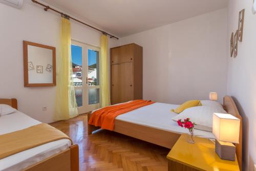a bedroom with two beds and a window at Apartments Marija Bibić in Hvar