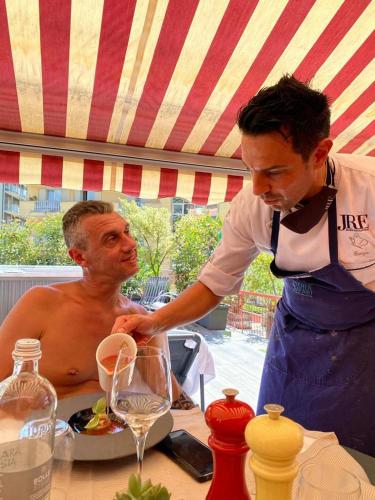 a man is standing next to a man at a table at Hotel Ristorante Eurossola in Domodossola