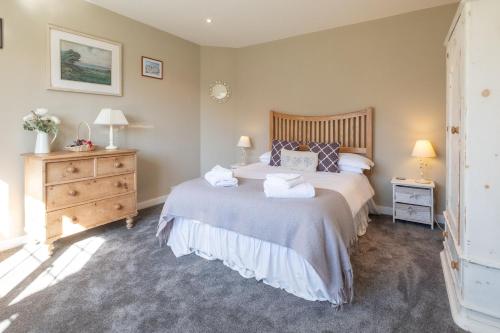 a bedroom with a bed and a dresser with two lamps at 6 Lakeside Avenue in Thorpeness