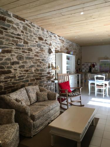 un salon avec un canapé et un mur en pierre dans l'établissement Le roc de l'aigle, à Cabrespine