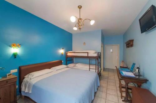 a blue bedroom with a bed and a tv at B&B Casa Roman & Vakantiewoning voor 1 pers tot max 32 personen in Zonhoven