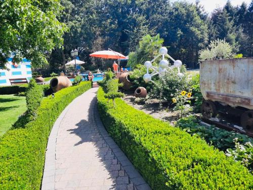 a walkway in a garden with an old rusty truck at B&B Casa Roman & Vakantiewoning voor 1 pers tot max 32 personen in Zonhoven