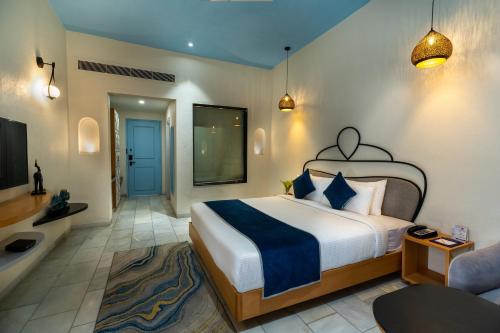 a bedroom with a bed and a tv and a couch at Ramee Royal Resort & Spa - Udaipur in Udaipur