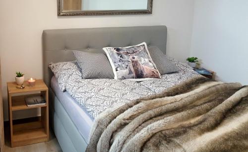 a bed with a blanket and a pillow on it at Village Romantic Apartments by Český Krumlov - adults only in Střížov