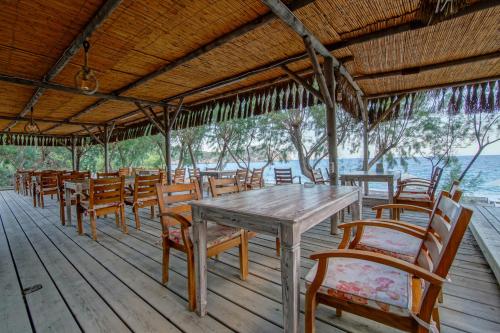 a wooden table and chairs on a deck at Ova Butik Otel in Mesudiye