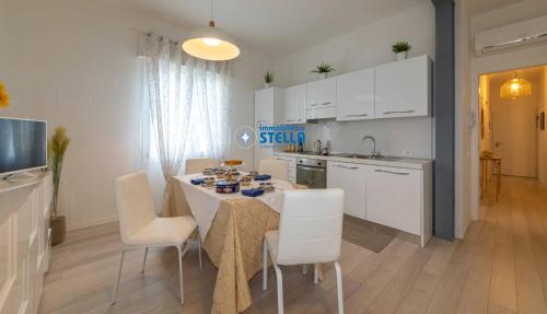 cocina y comedor con mesa y sillas en Condominio Sirene, en Lido di Jesolo