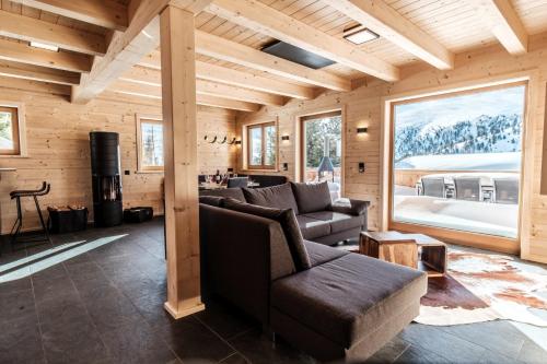 a living room with a couch and a table at Heidi Chalets Falkert Heidialm - Chalets Bergwinter in Patergassen