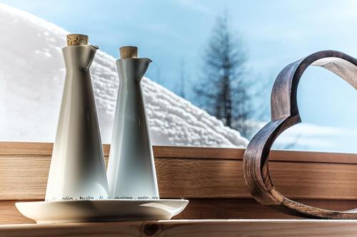 two vases sitting on a window sill with snow at Heidi Chalets Falkert Heidialm - Chalets Bergwinter in Patergassen