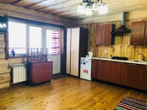 cocina con suelo de madera y nevera en una habitación en У Віти номер2 en Synevyrsʼka Polyana