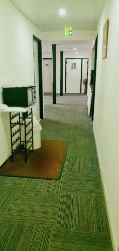 an empty hallway with a room with a microwave at Glisy Hôtel in Glisy