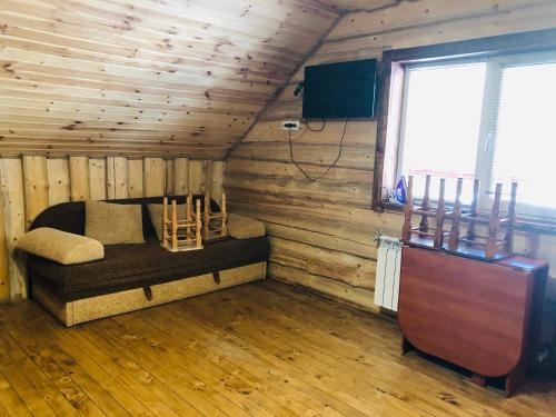 Habitación con cama en una cabaña de madera en У Віти номер2 en Synevyrsʼka Polyana
