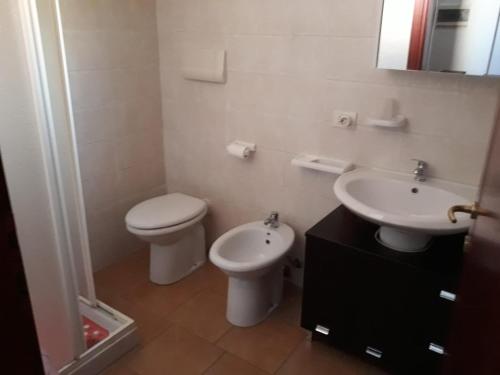 a bathroom with a toilet and a sink at Airport 25 min ByWalk-Big Port 10 min by bus-Bus 1 min by walk to city&beaches-Touristic port at 1 min by walk - WIFI AIR COND WASH MACHINE -4 pex 2 Rooms veranda&GARDEN-FREE PARKING-GIALLO in Olbia