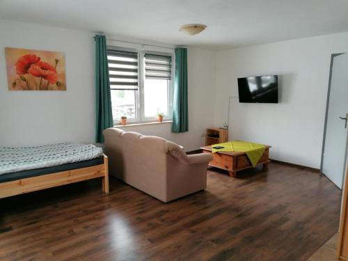 a living room with a couch and a bed at Ellen`s Pension in Dobbrun