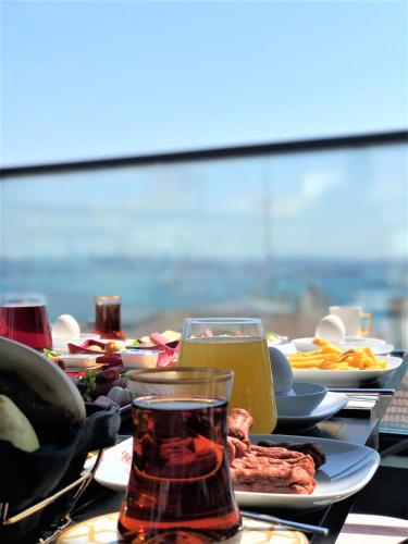 a table with plates of food and a glass of juice at Ferman Port Hotel - Special Category in Istanbul