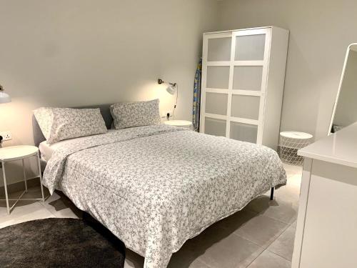a white bedroom with a bed and a table at Forest View Apartments in Kololi