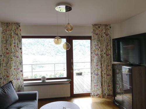 a living room with a large window and a television at Hotel Hegenbarths in Cochem