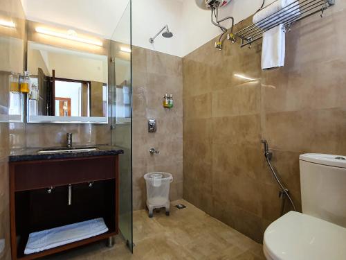 a bathroom with a shower and a toilet and a sink at LP Residency in Dehradun