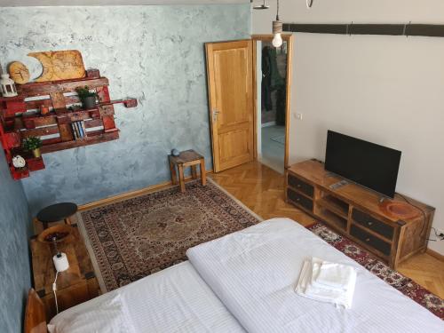 - un salon avec un lit et une télévision dans l'établissement Apartment Aviatiei 61, à Bucarest