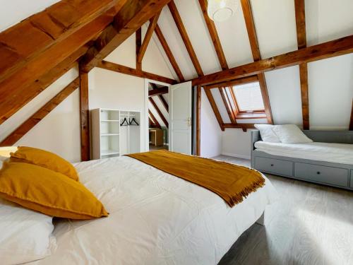 a bedroom with a bed and a couch in a attic at Le Cocon - Classé 3 étoiles - Avec garage, à 5mn du centre in Strasbourg