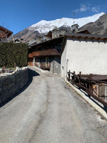 a dirt road next to a building with a snow covered mountain at Casa Netto in Morgex