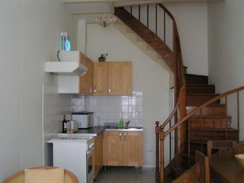 una cocina con armarios de madera y una escalera en una habitación en Orion, In A Complex Of 7 Gites, Les Constellations, en Doeuil-sur-le-Mignon