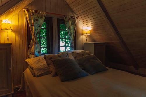 um quarto com uma cama com almofadas e uma janela em Domki Victoria em Sasino