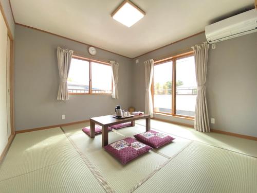 a living room with a table and two windows at LINK HOUSE in Fujiyoshida