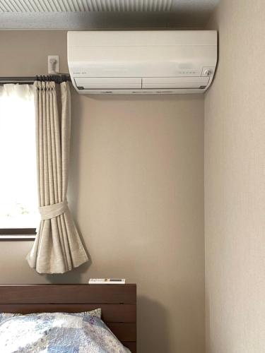 a bedroom with a air conditioner on the wall at LINK HOUSE in Fujiyoshida