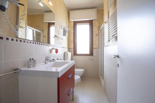 a bathroom with a sink and a toilet and a mirror at Hotel Deborah in Milano Marittima