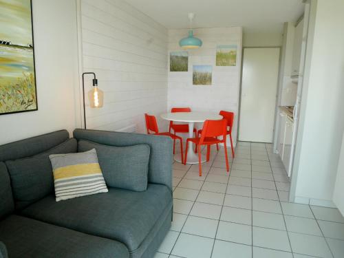 un salon avec un canapé et une table dans l'établissement REF 041 Appartement pour quatre personnes vue mer accès plage et parc du Fogeo ARZON, à Arzon