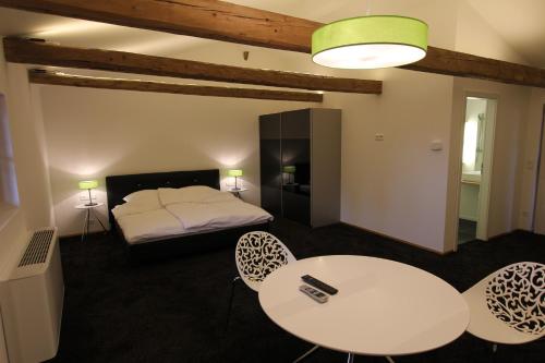 a room with a bed and a table and chairs at Appartements Bad Birnbach in Bad Birnbach
