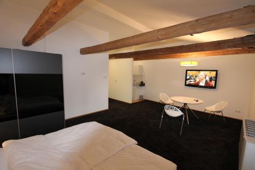sypialnia z łóżkiem, stołem i krzesłami w obiekcie Appartements Bad Birnbach w mieście Bad Birnbach