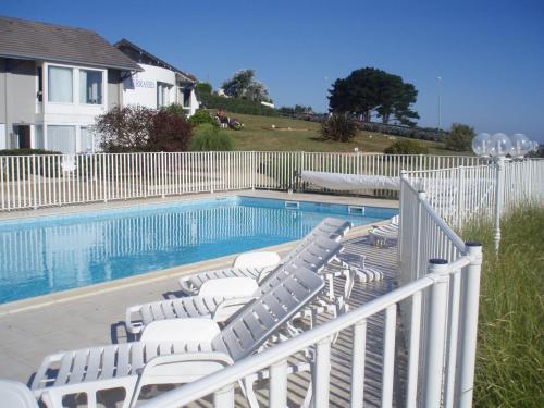 - une piscine avec chaises longues et clôture dans l'établissement BELLE VUE MER STUDIO PISCINE, à Trévou-Tréguignec