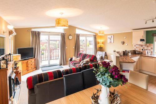 a living room with a couch and a table at Hunters Lodge With Hot Tub in Malton