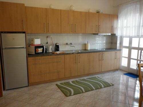 a kitchen with wooden cabinets and a refrigerator at Manor Villa in Hévíz