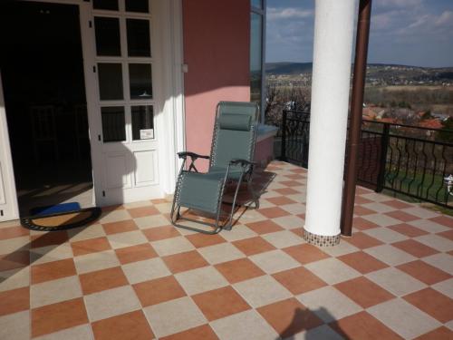 two chairs on a porch with a checkered floor at Manor Villa in Hévíz