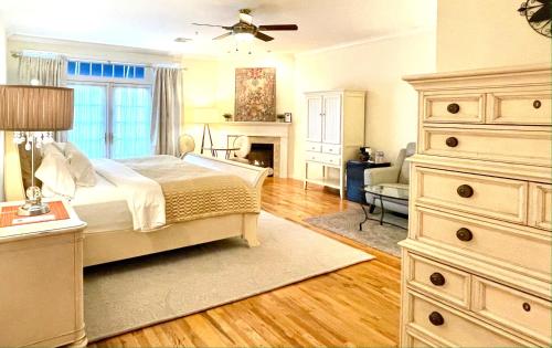 a bedroom with a bed and a dresser and a fireplace at Inn on Main Hotel in Manasquan