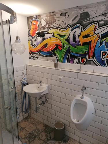un baño con un urinario y una pintura en la pared en Tina´s Fewo en Hohendodeleben