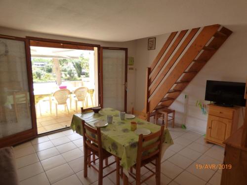 une salle à manger avec une table et des chaises et un balcon dans l'établissement Pavillon T2, cabine, mezzanine, Narbonne Plage, à Narbonne-Plage
