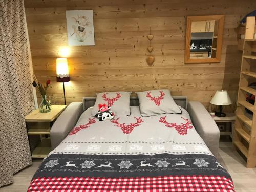 a bedroom with a bed with red and white blankets at Ambrunes 9 - Grand studio rénové dans le centre de Châtel in Châtel