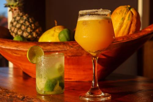 un vaso de zumo junto a un bol de fruta en Pousada Iansã, en Ponta do Anel